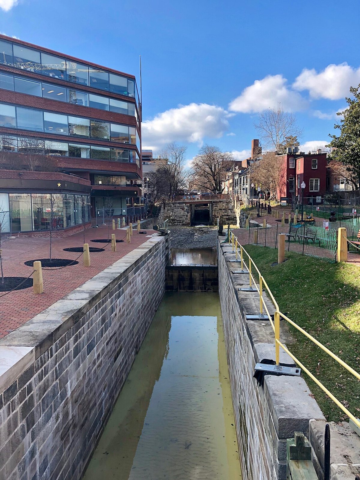 morning light on the C&O Canal towpath in Georgetown with a jogger passing a stone lock